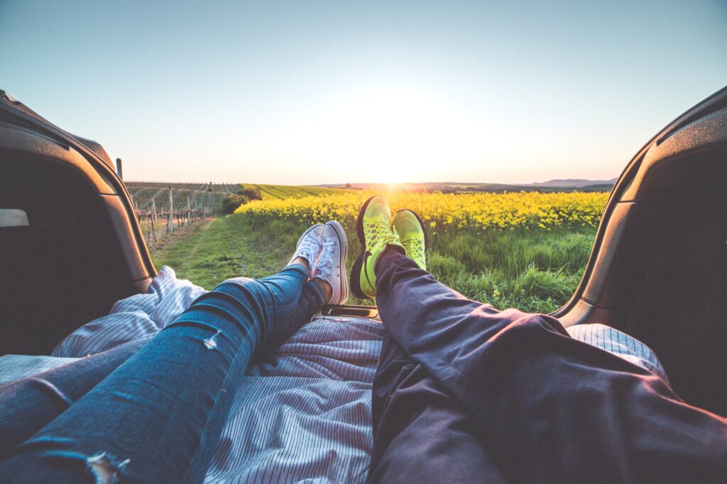 3 Tips To Decrease Your Neck and Shoulder Pain While Working From Home laying in the trunk of a car by grass field