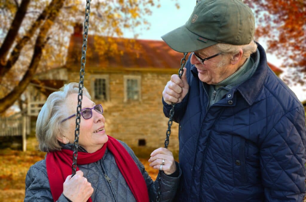 5 Most Common Causes of Back Pain, older couple swinging in the park